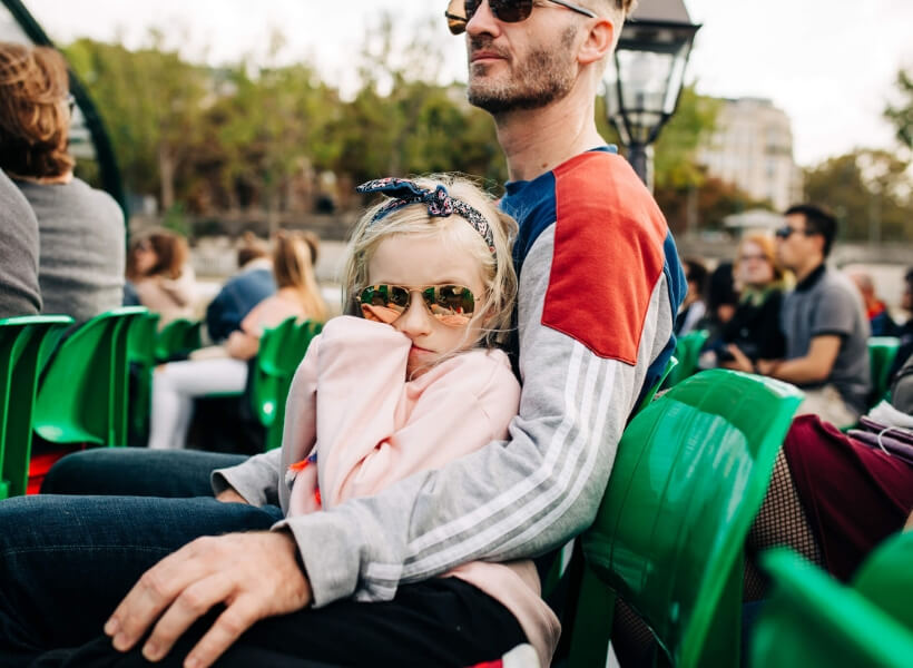 Father and girl sitting on chairs and enjoying their cruise on the bateaux mouches: vacation photos episode