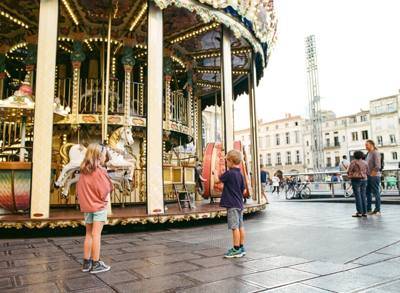 children looking at a carrousel in Montpellier: Great Destinations in France for Families episode