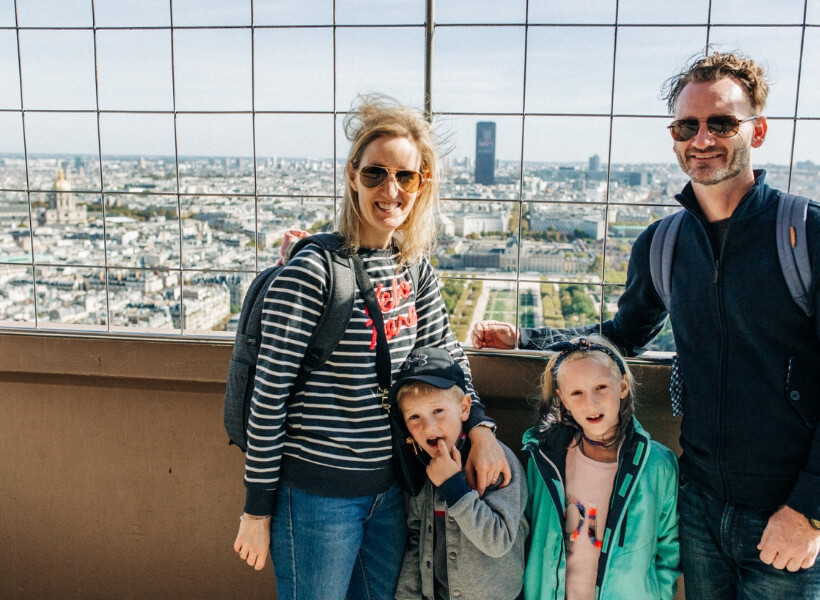 Jessica and her family posing on top of the Eiffel Tower: vacation photos