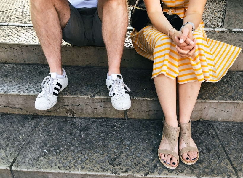 man and woman sitting on steps, the photo only shows their legs and shoes: vacation photos