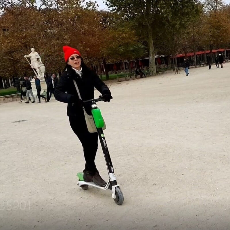 Eric's wife riding a scooter inside the Luxembourg Gardens