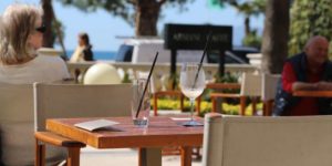 Seaside café with empty glasses on a table and the sea in the background