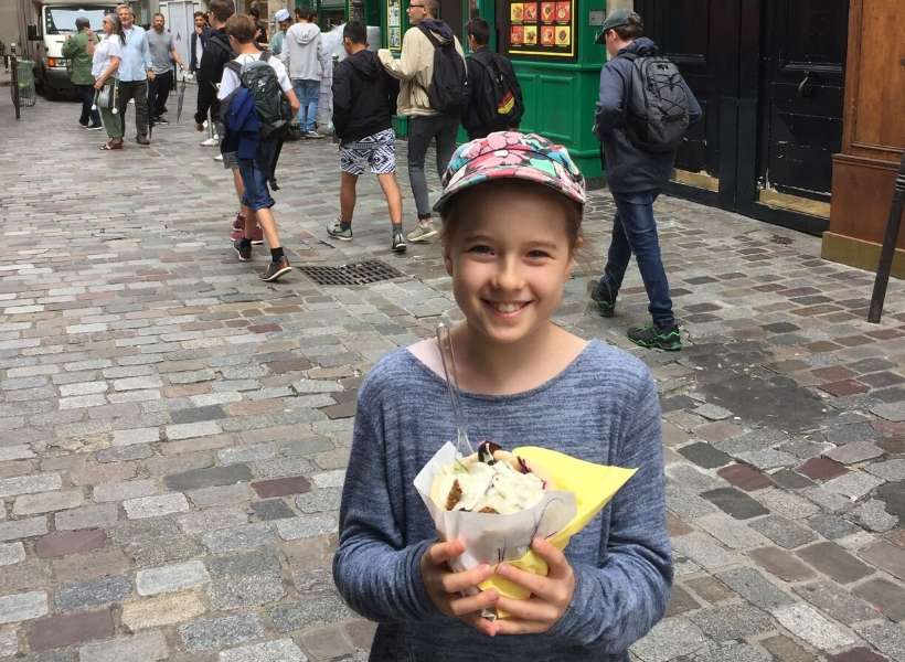 Joanne's daughter holding her fallafel sandwich from As du Fallafel in the Marais