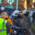 yellow vest protestor facing police officers