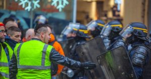 yellow vest protestor facing police officers