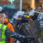 yellow vest protestor facing police officers