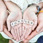 Man and woman hand-holding with the words forever written with Scrabble tiles: honeymoon in Provence episode
