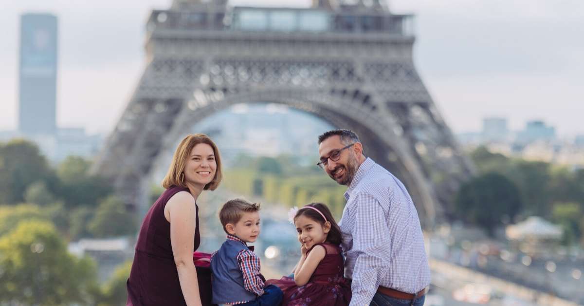 Michelle and family posing in front of the Eiffel Tower: Paris with Preschoolders episode