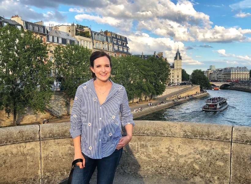 Lauren standing on a bridge in Paris: solo in Paris episode