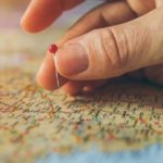 Woman placing a pin on a map: Best Practices When Preparing a Trip to France episode