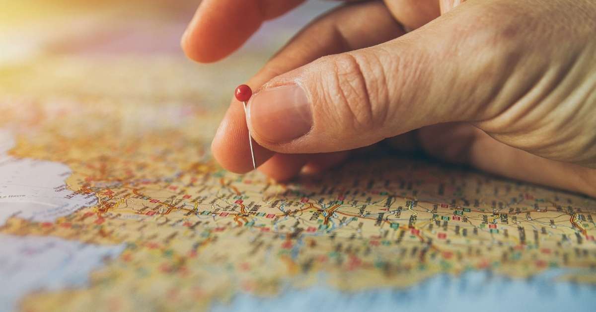 Woman placing a pin on a map: Best Practices When Preparing a Trip to France episode