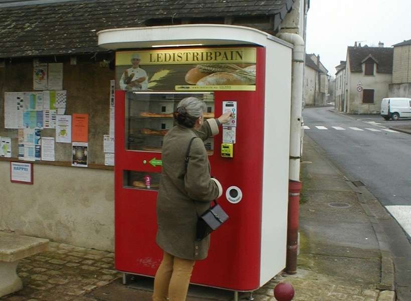 Susan buying bread from a bread vending machine