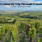 A hilly French countryside with a vineyard in the foreground: A Leisurely Trip Through France episode