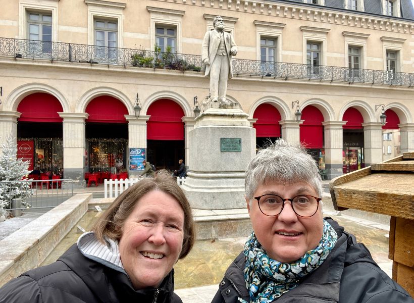 Annie and Jennifer on a visit to Castres with a statue of Jean Jaurès behind them
