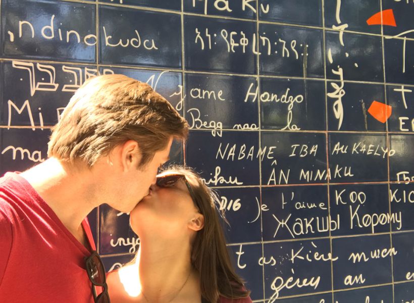 Kathrine and her husband kissing in front of the Wall of Love in Montmartre: Romantic Getaways in Paris episode